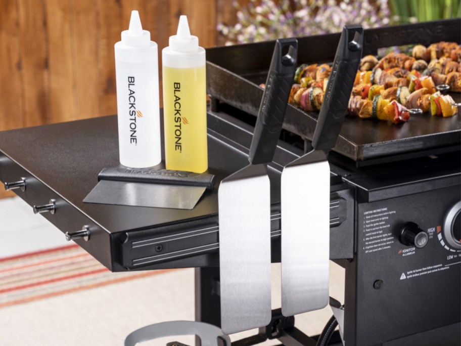 blackstone tools and bottles on side shelf of griddle