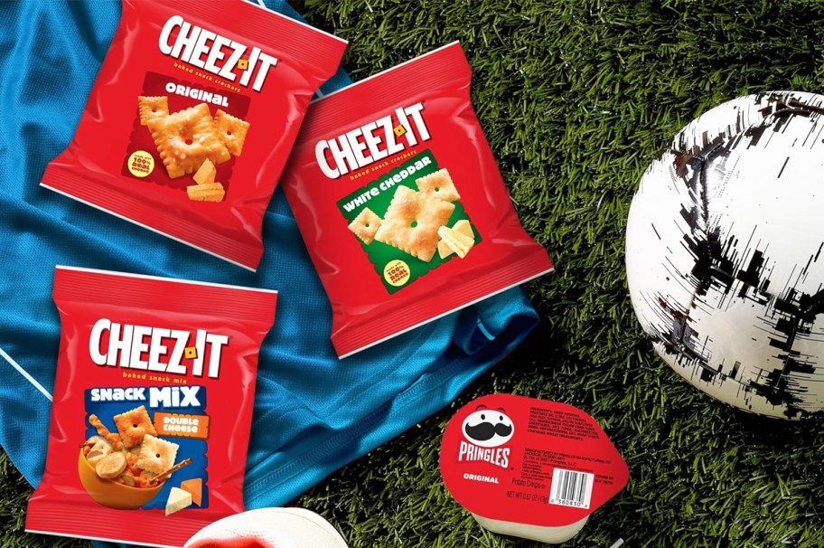 bags of Cheez-It & Pringles on grass near soccer ball