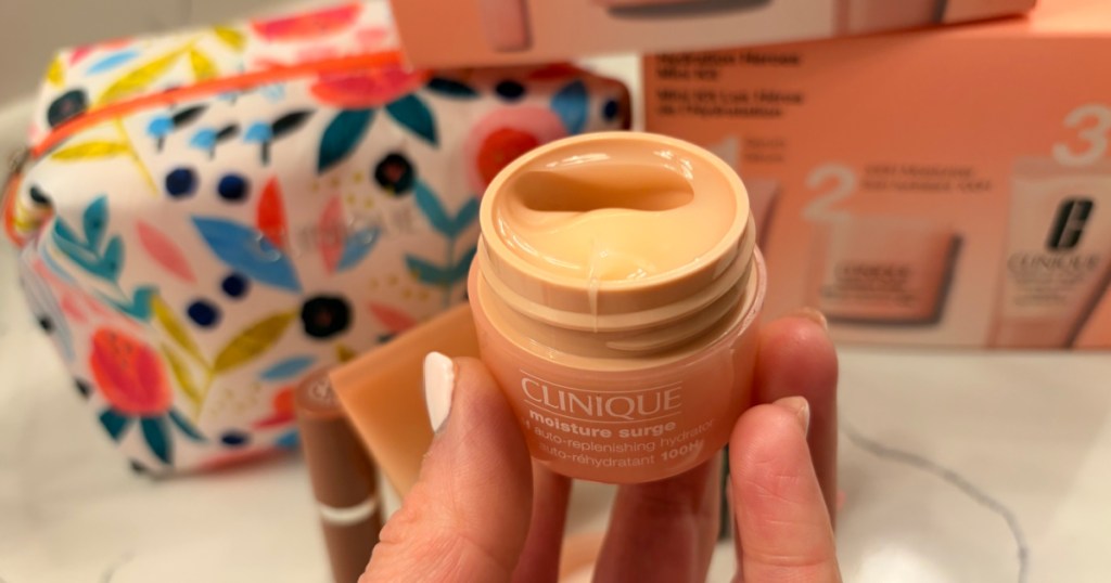 Hand holding up Clinique moisture surge