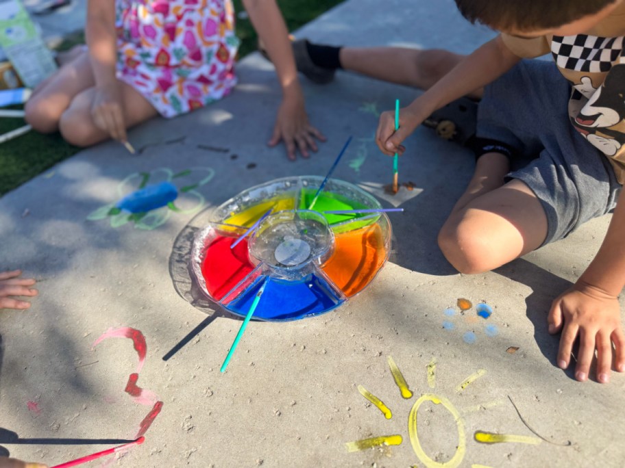 kids painting with chalk on the sidewalk