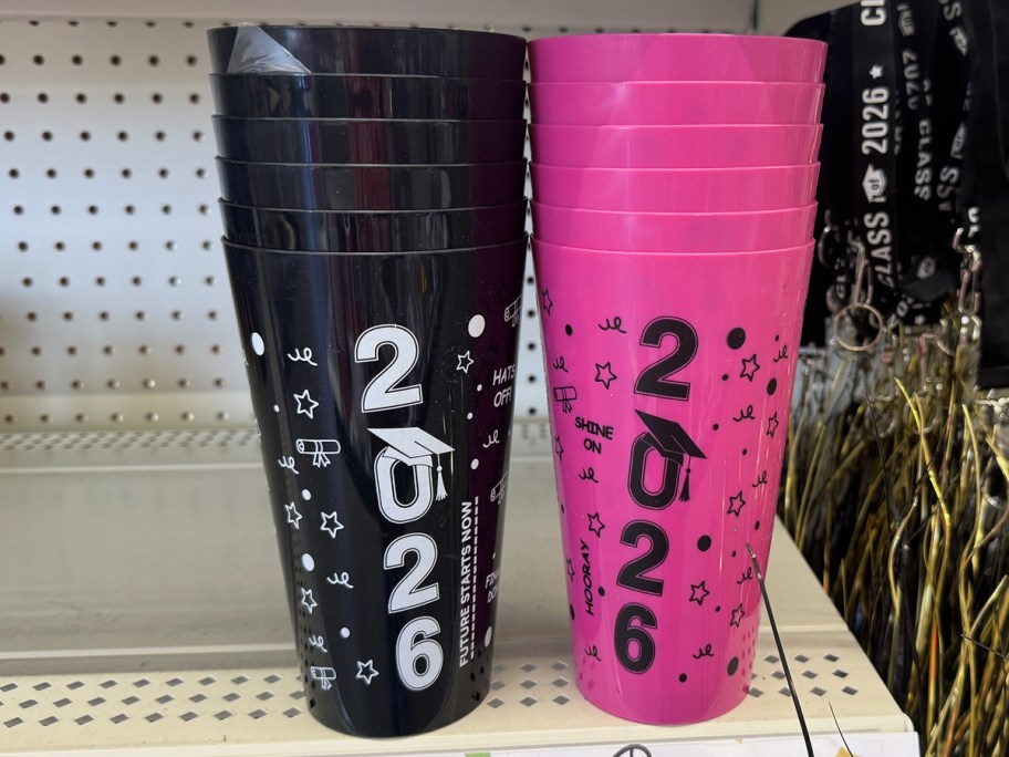 stacks of black and pink graduation cups on store shelf