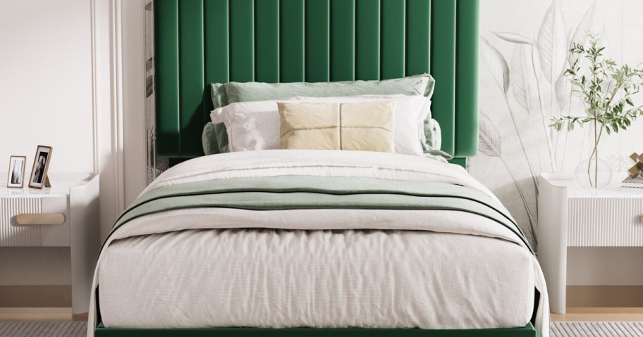 A neatly made bed with a green headboard features layered white and mint green bedding. Flanked by white nightstands.