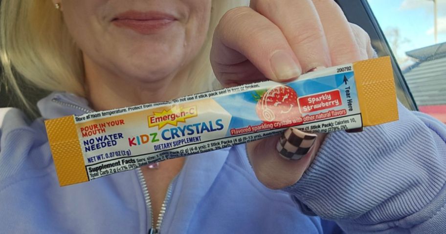 Hand holding up a single serve stick of Emergen-c Kidz Crystals