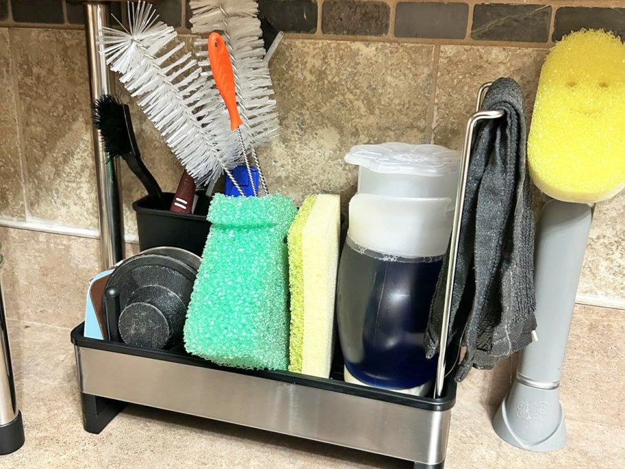 sponges and brushes in a sink caddy