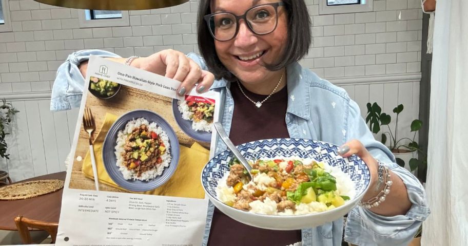 Woman holding up a Home Chef recipe guide and a plate of food with the finished recipe