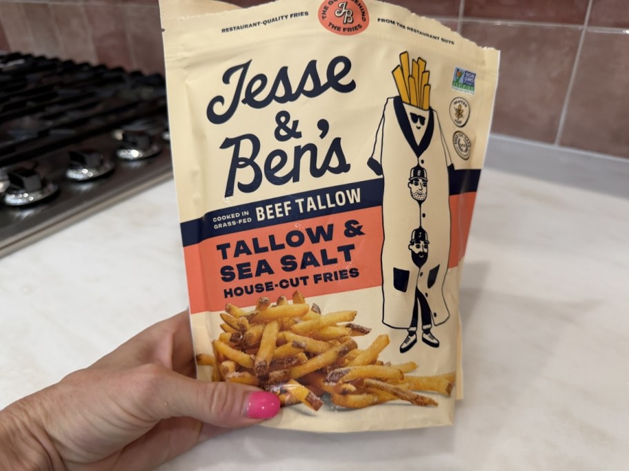 person holding bag of jesse & ben's beef tallow french fries in kitchen
