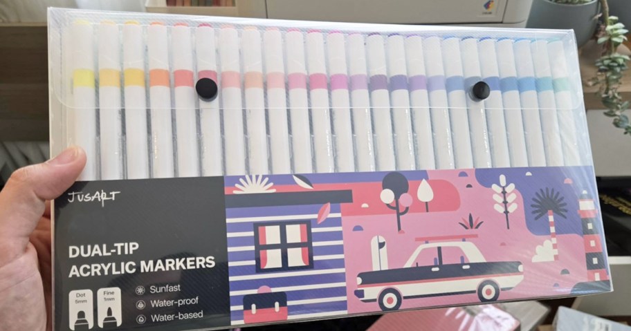 hand holding a pack of JusArt Dual-Tip Acrylic Paint Markers