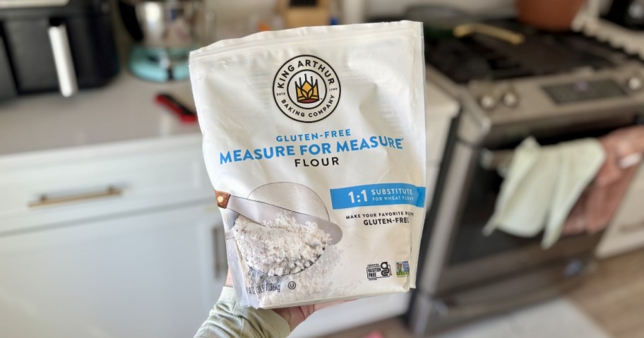 person holding bag of king arthur measure for measure gluten-free flour in kitchen