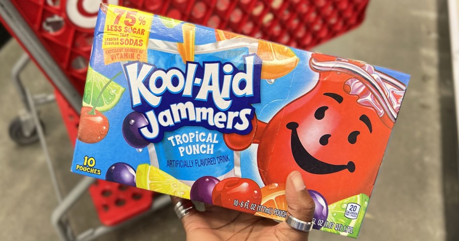 hand holding a box of Kool-Aid Jammers near a red shopping cart