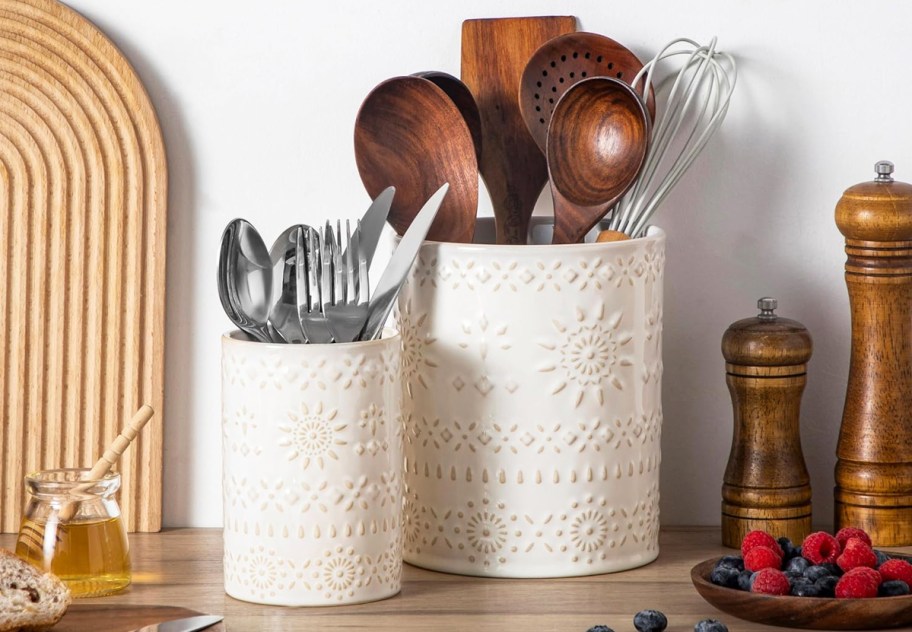 wooden spoons and flatware in ceramic utensil holders on counter