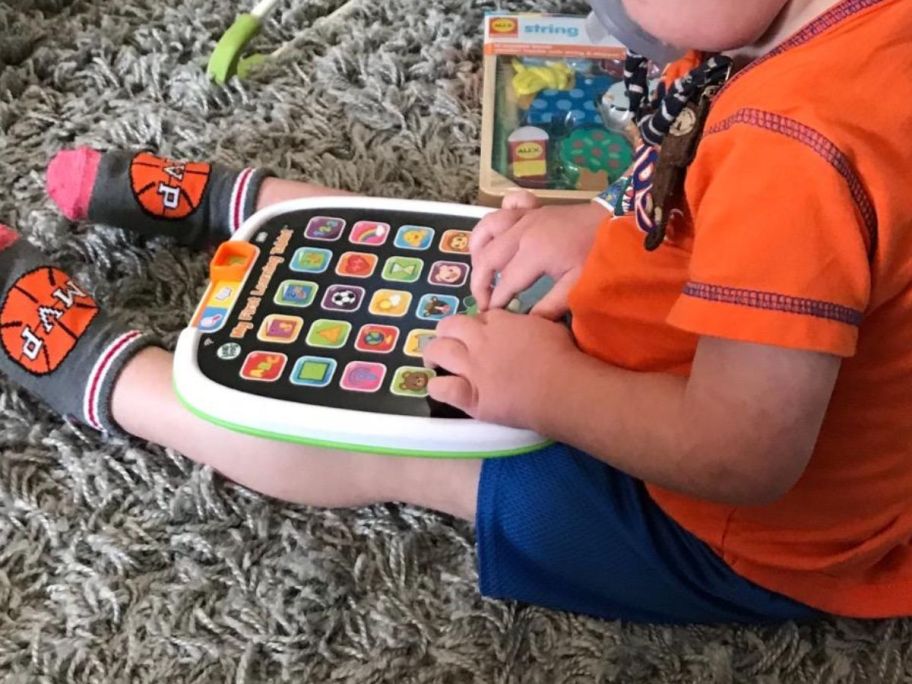 kid playing with LeapFrog My First Learning Tablet on floor
