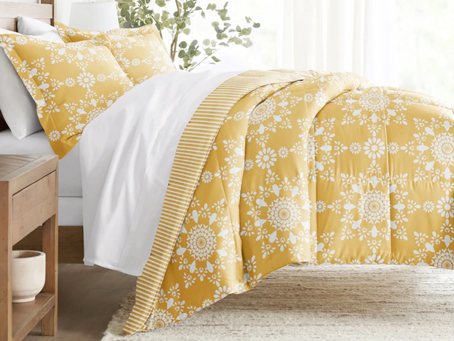 yellow and white medallion print comforter and pillow shams on a bed
