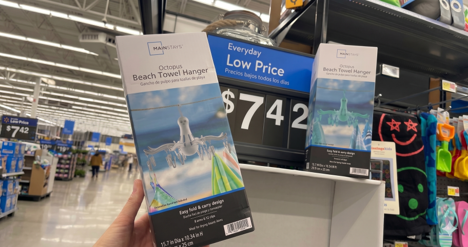 Mainstays octopus beach towel hanger box in hand in front of a sale sign in-store