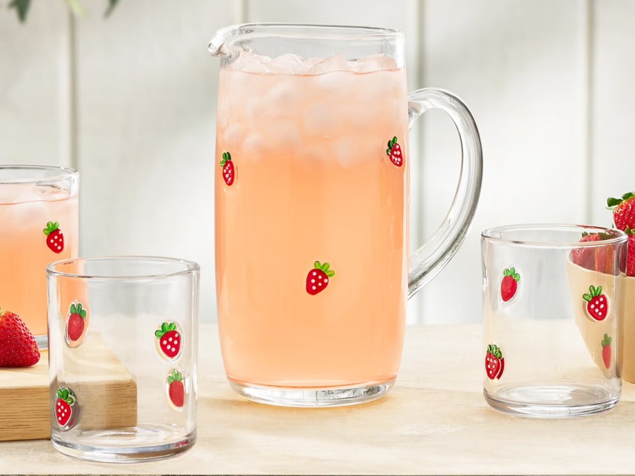 glass pitcher and cups with strawberry icons on them