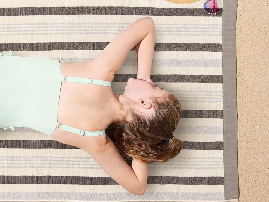 person laying on Member's Mark Kids Sand-Resistant Beach Towel