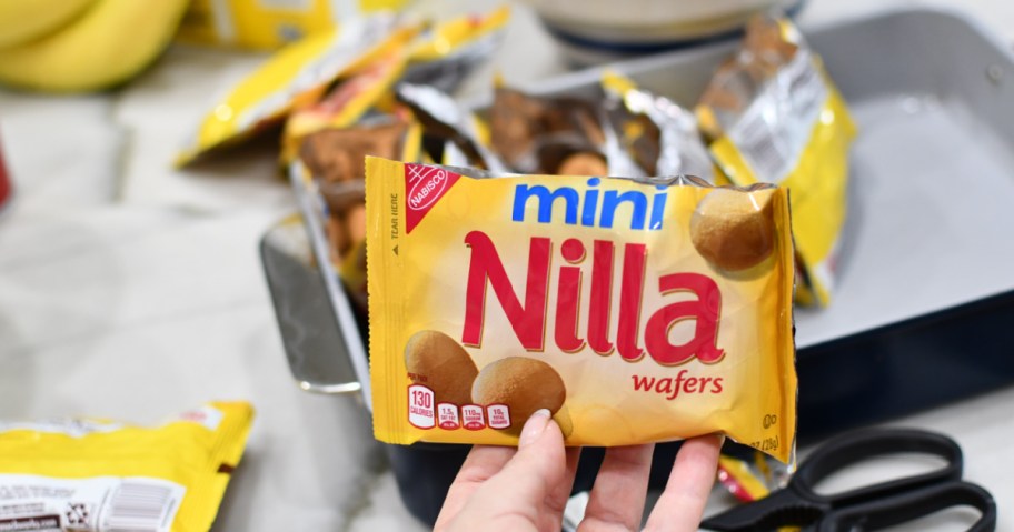 Woman holding up bag of mini vanilla wafers cookies