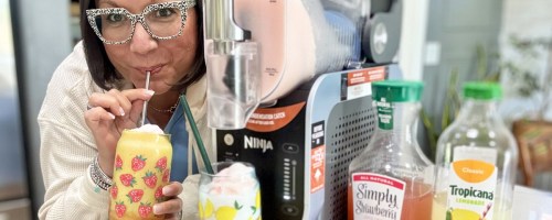 woman sipping a drink next to Ninja SLUSHi machine