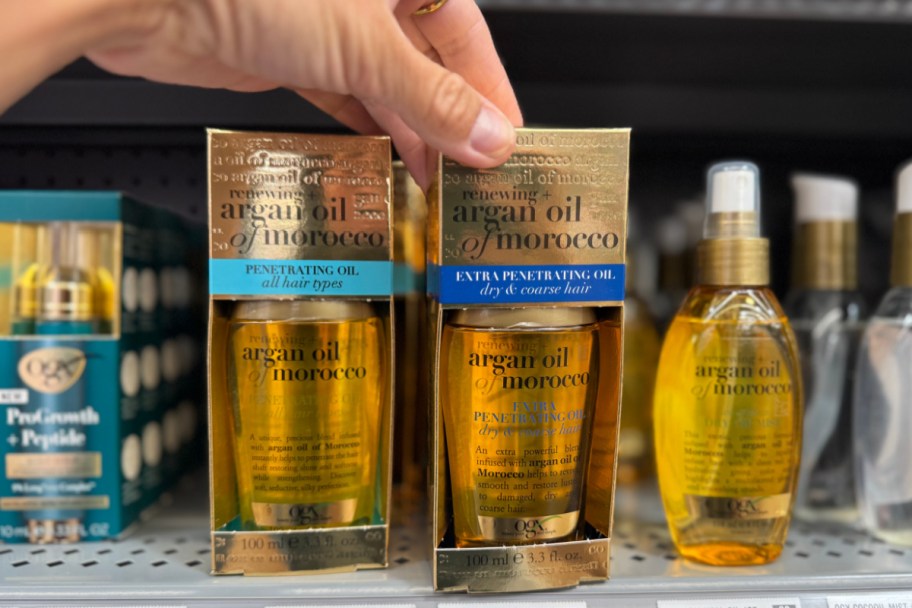 hand grabbing golden hair oil off shelf