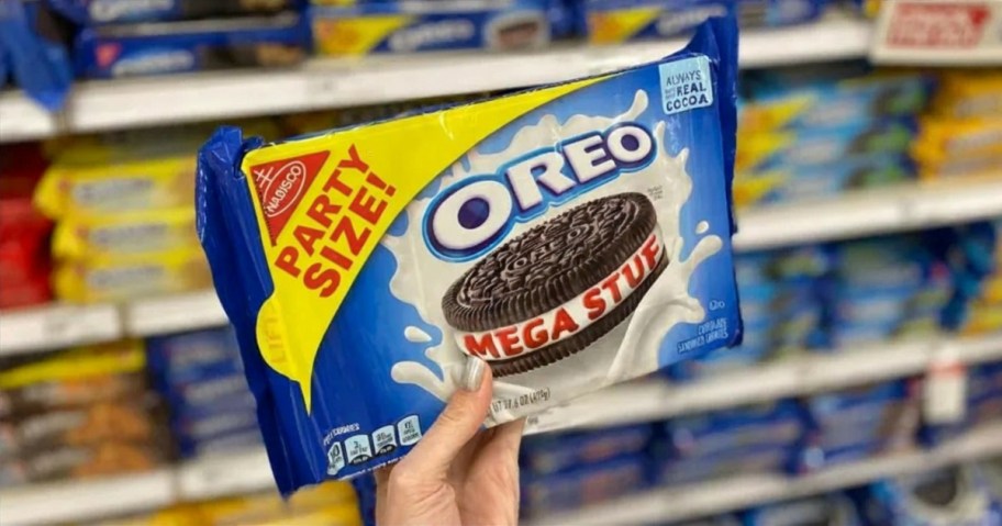 person holding package of mega stuf oreo cookies in store