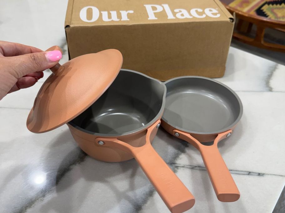 Our Place Tinies Cookware Set with 2 pans in front of an Our Place Box