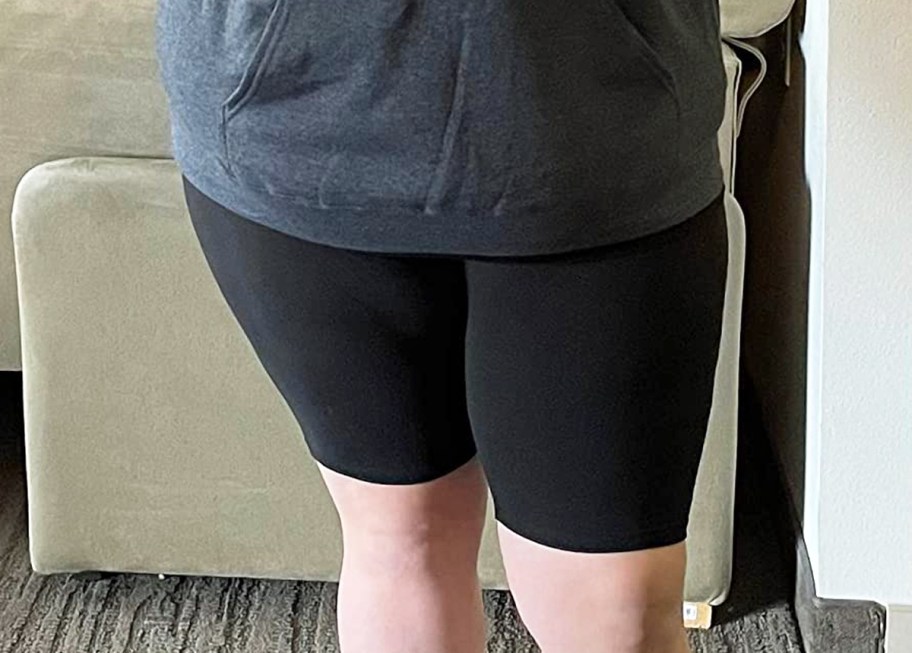 woman wearing grey hoodie and black bike shorts