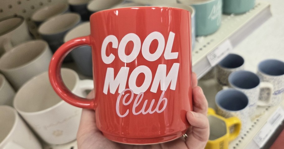 hand holding a red mug that says "cool mom club"