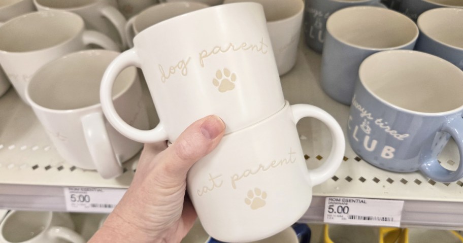 hand holding white mugs that say dog & cat parent