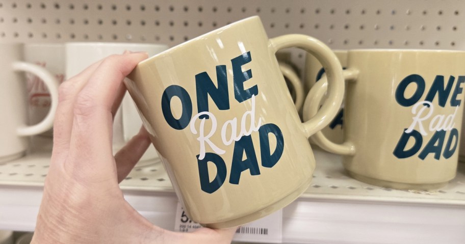 hand holding a mug that says "one rad dad"