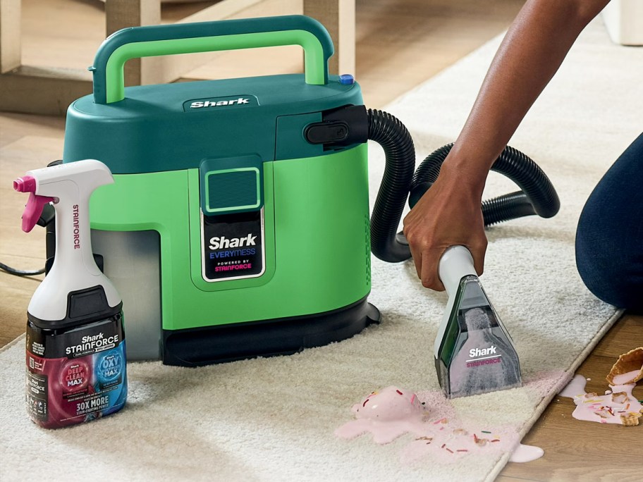person cleaning spill on carpet with green Shark EveryMess machine