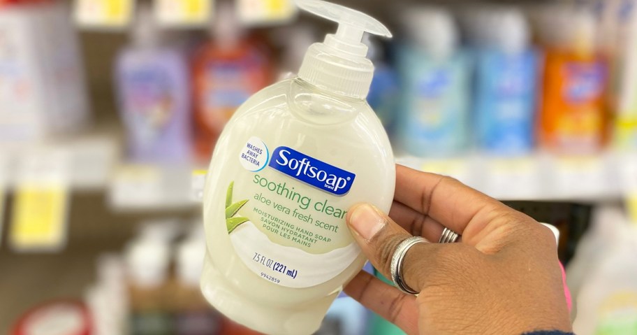 hand holding a white bottle of Softsoap Hand Soap in store