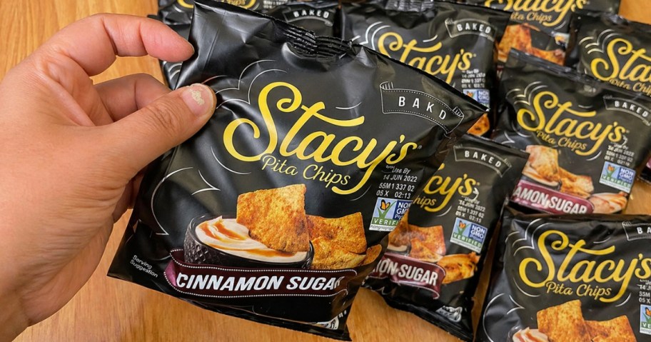 hand holding a snack bag of Stay's Cinnamon Sugar Pita Chips with more behind it
