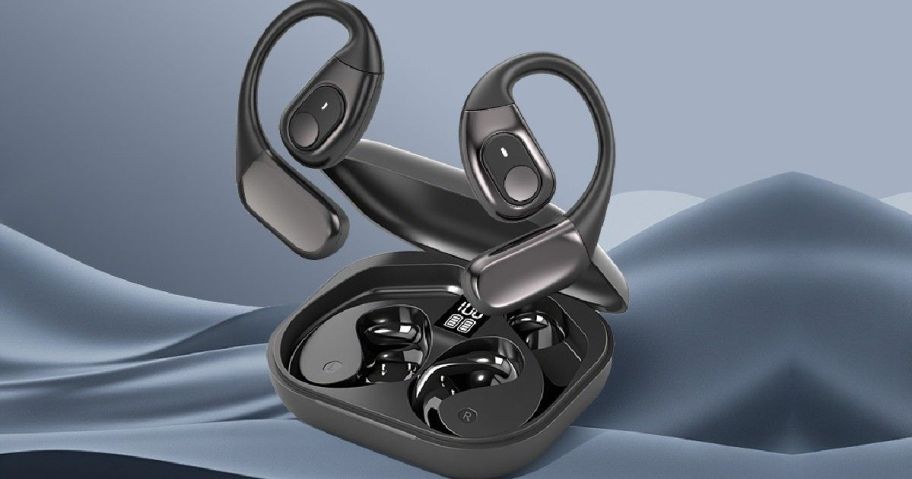 Sleek black wireless earbuds with over-ear hooks are displayed above an open charging case. The background features soft, blue fabric folds.