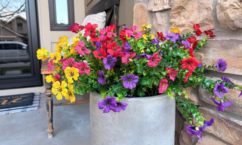 colorful flowers in cement pot on front porch