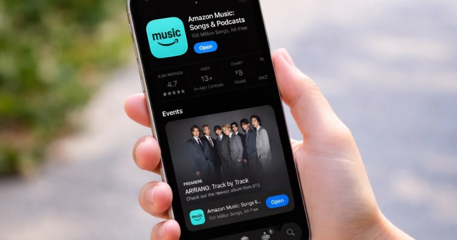 hand holding a phone with the Amazon Music app on it