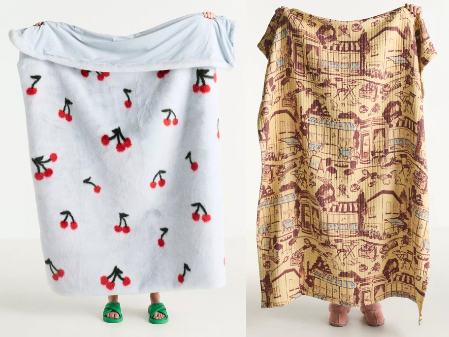 people holding up blue and tan blankets 