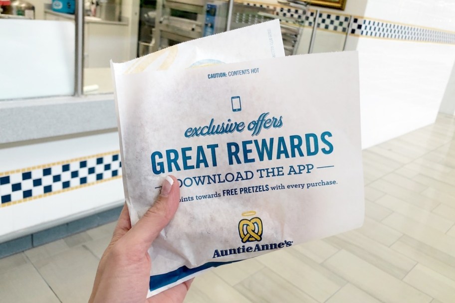 womans hand holing an auntie annes paper wrapper