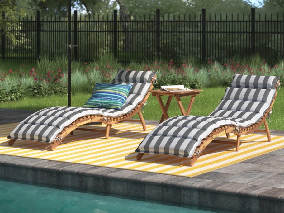 striped lounge chairs next to pool 