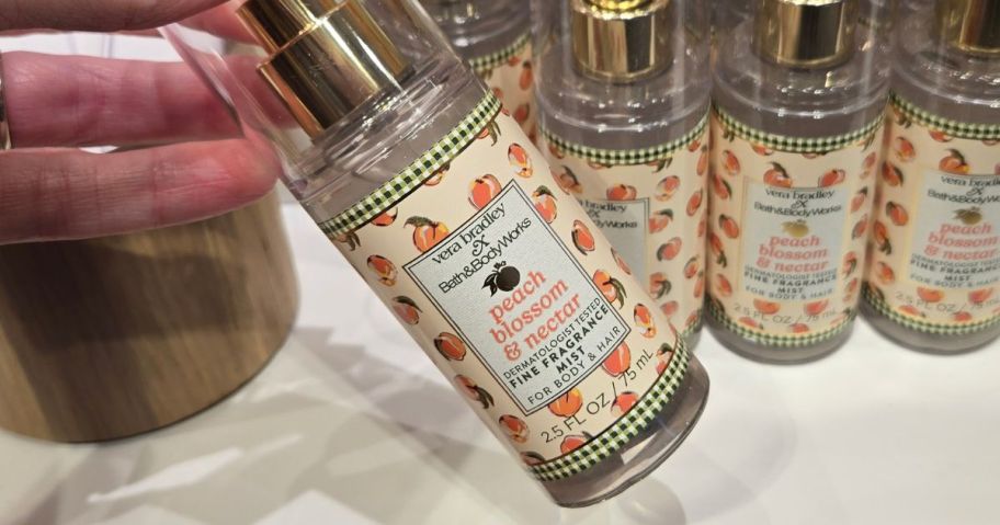 hand holding bath and body works Peach Blossom & Nectar Travel Size Fine Fragrance Mist in store