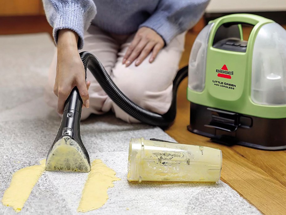 woman using little green carpet cleaner on spill
