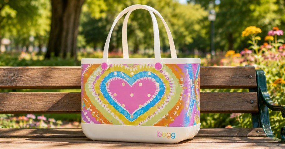 a colorful heart print Bogg Bag sitting on a park bench