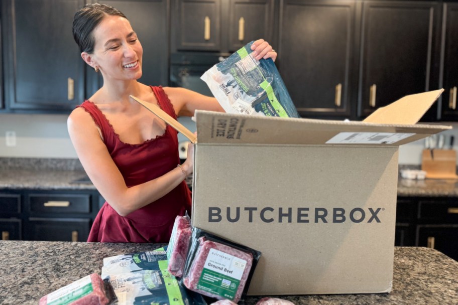 woman unboxing box of frozen meats