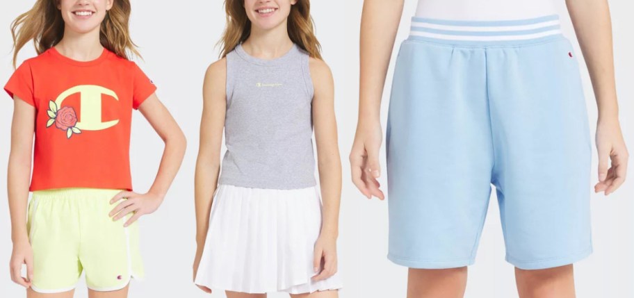 Three Champion girls' athletic outfits displayed side by side, featuring an orange t-shirt with a floral logo paired with yellow shorts on the left, a grey tank top with a pleated white skirt in the middle, and light blue sweatshorts with a striped waistband on the right.