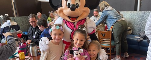 kids standing in front of minnie mouse who is wearing a chef's hat