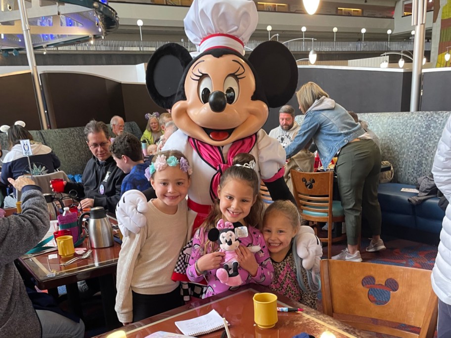 kids standing in front of minnie mouse who is wearing a chef's hat