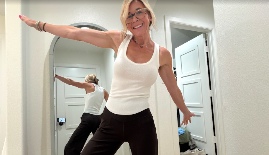 woman standing in front of mirror with arms wide open