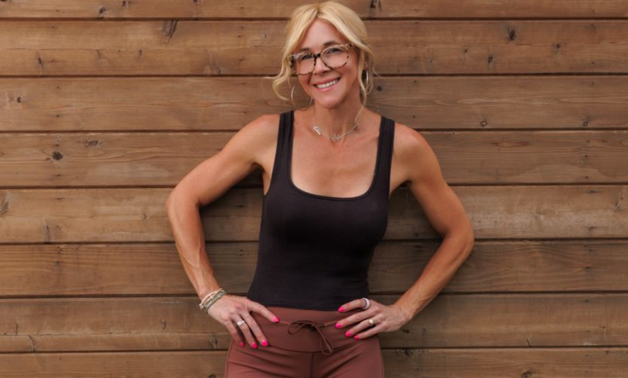 woman posing against wooden panel wall