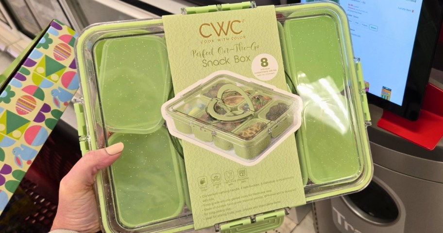 A hand holds a green snack box set 