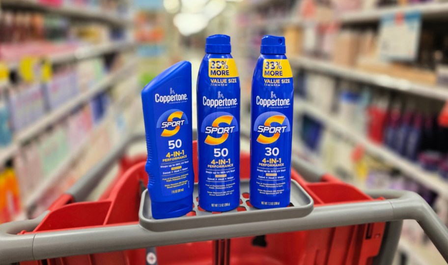 three coppertone sport sunscreens lined up on a target cart in store