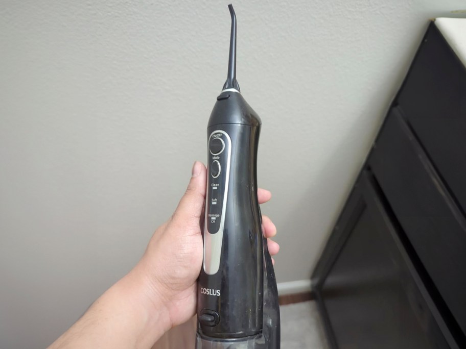 hand holding black water flosser 