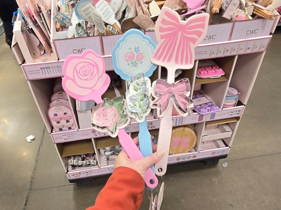 hand holing three spatulas with bows and flowers 